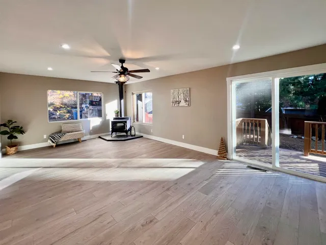 a room with a chandelier and wooden floor
