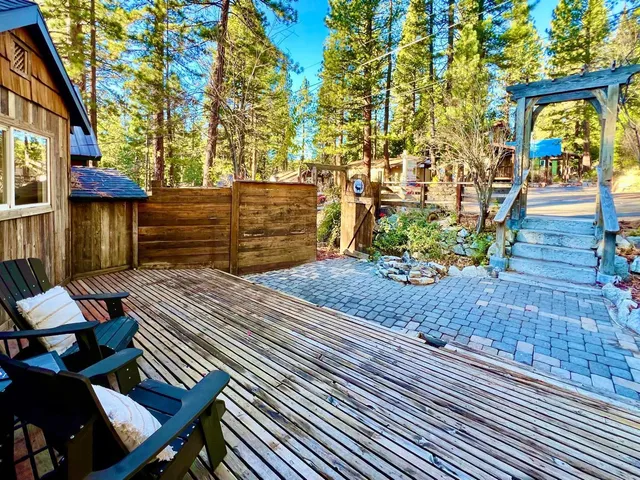 a view of a patio with table and chairs with wooden floor and fence