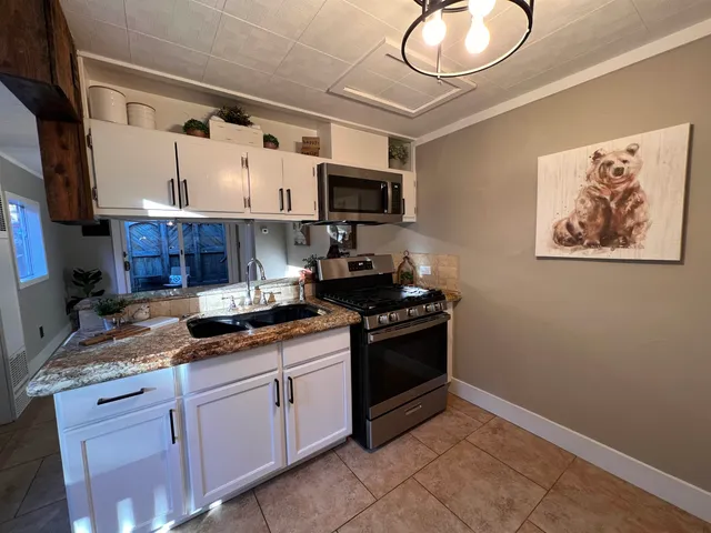 a kitchen with stainless steel appliances granite countertop a stove and a sink