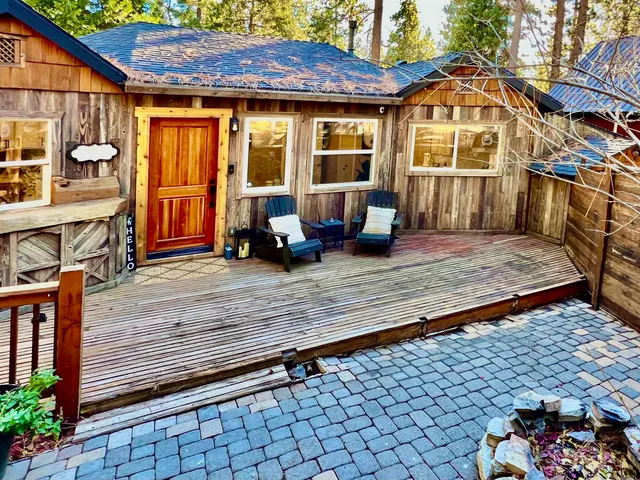 a view of a wooden chairs and a small yard in the patio