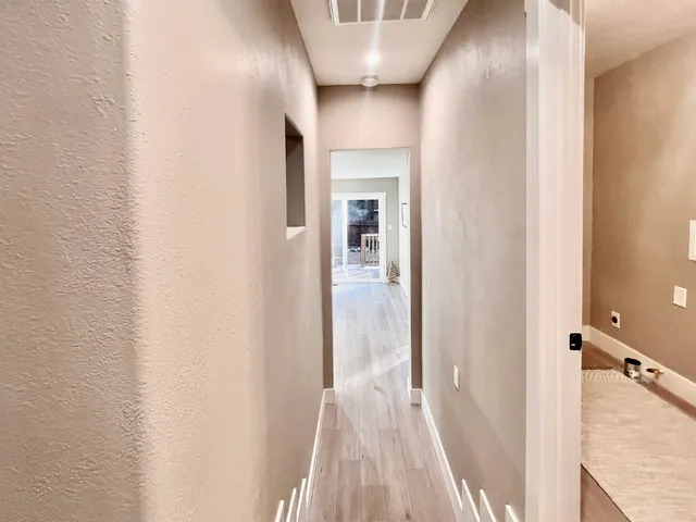 a view of a hallway with wooden floor and staircase