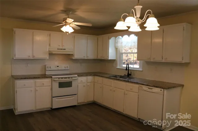 a kitchen with a white cabinets and chandelier