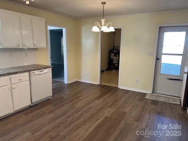 a view of a kitchen with wooden floor and cabinets