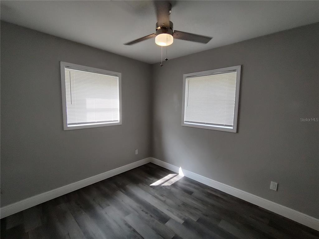 320 West Howry Avenue, Unit 1 Deland, FL 32720 - Photo 17 of 33 a view of an empty room with wooden floor and a window