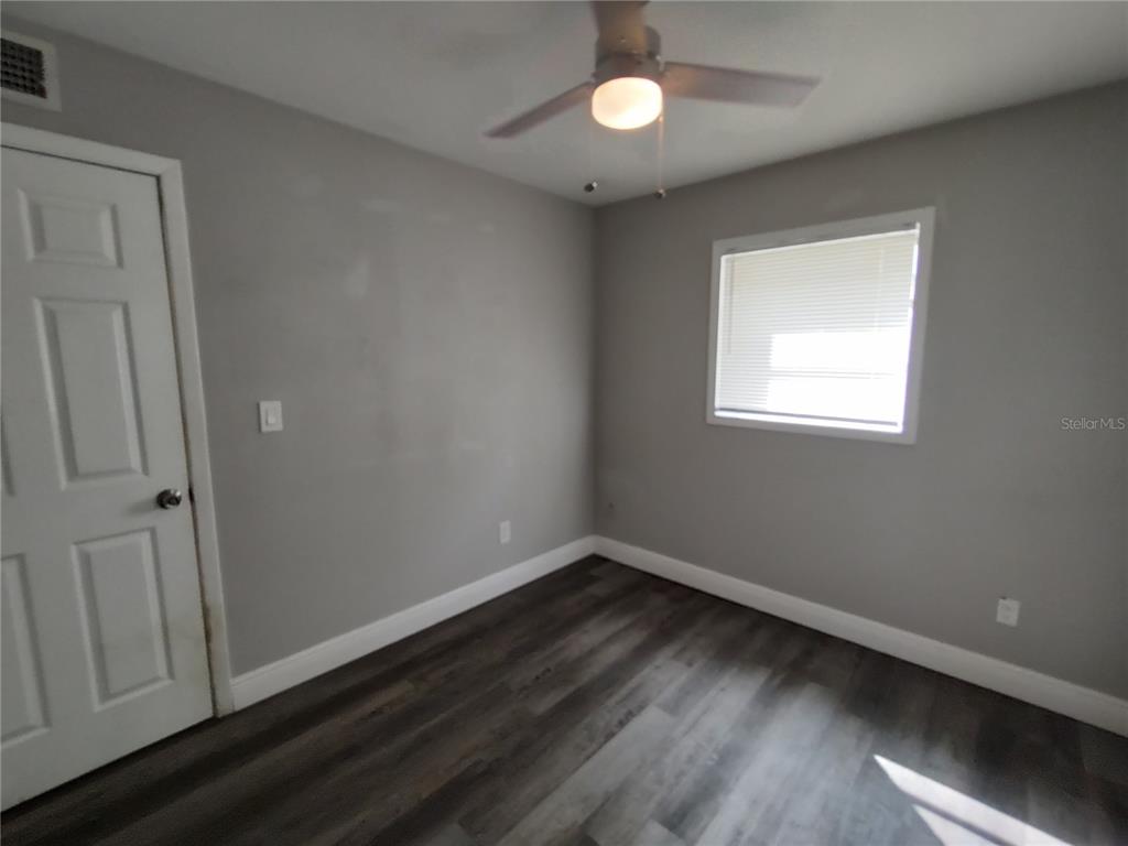 320 West Howry Avenue, Unit 1 Deland, FL 32720 - Photo 20 of 33 an empty room with wooden floor and windows