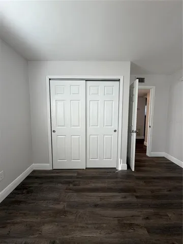 a view of room with wooden floor and ceiling fan