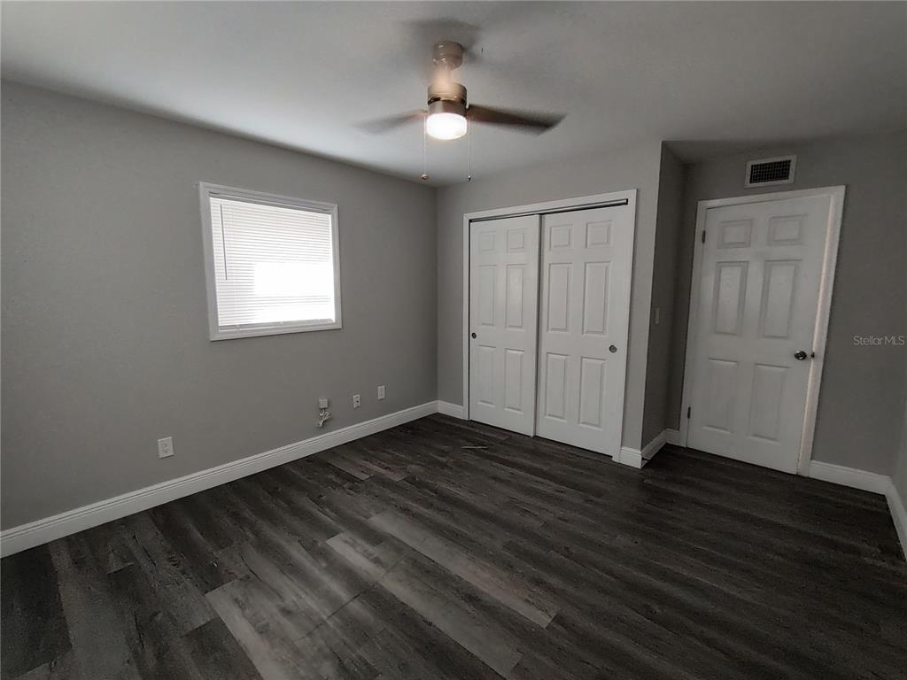 320 West Howry Avenue, Unit 1 Deland, FL 32720 - Photo 25 of 33 an empty room with wooden floor cabinet and windows