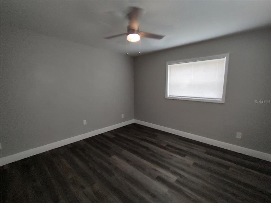 320 West Howry Avenue, Unit 1 Deland, FL 32720 - Photo 27 of 33 an empty room with wooden floor and windows