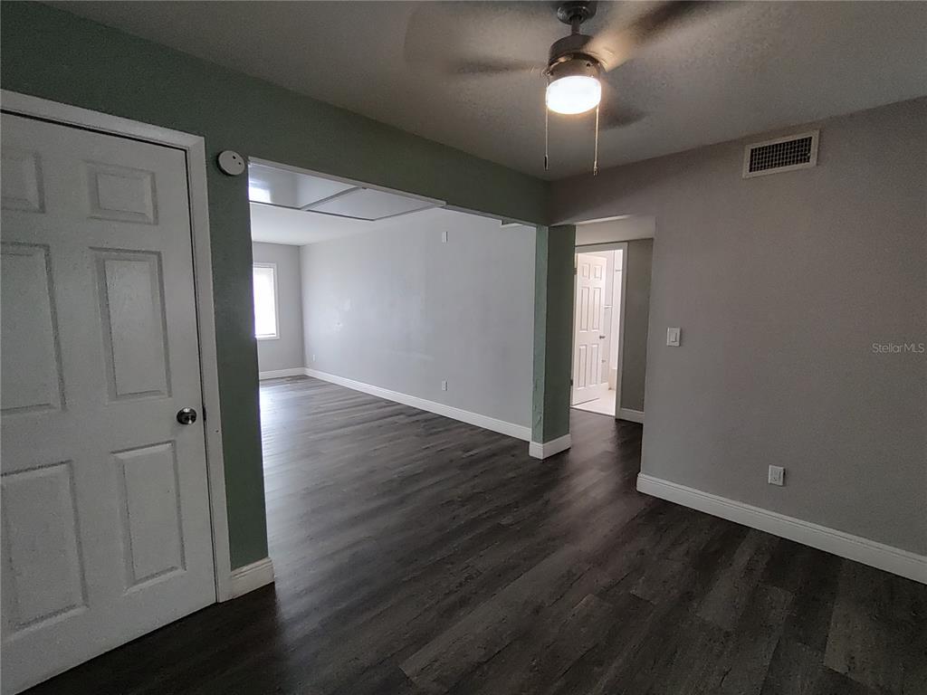 320 West Howry Avenue, Unit 1 Deland, FL 32720 - Photo 5 of 33 an empty room with wooden floor closet and windows