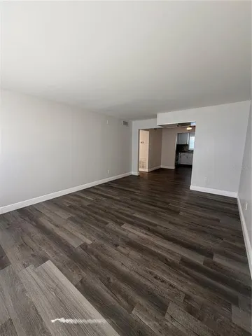 a view of empty room with wooden floor and cabinet