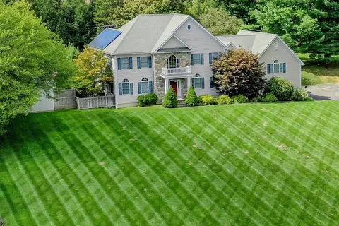 a aerial view of a house with yard and green space