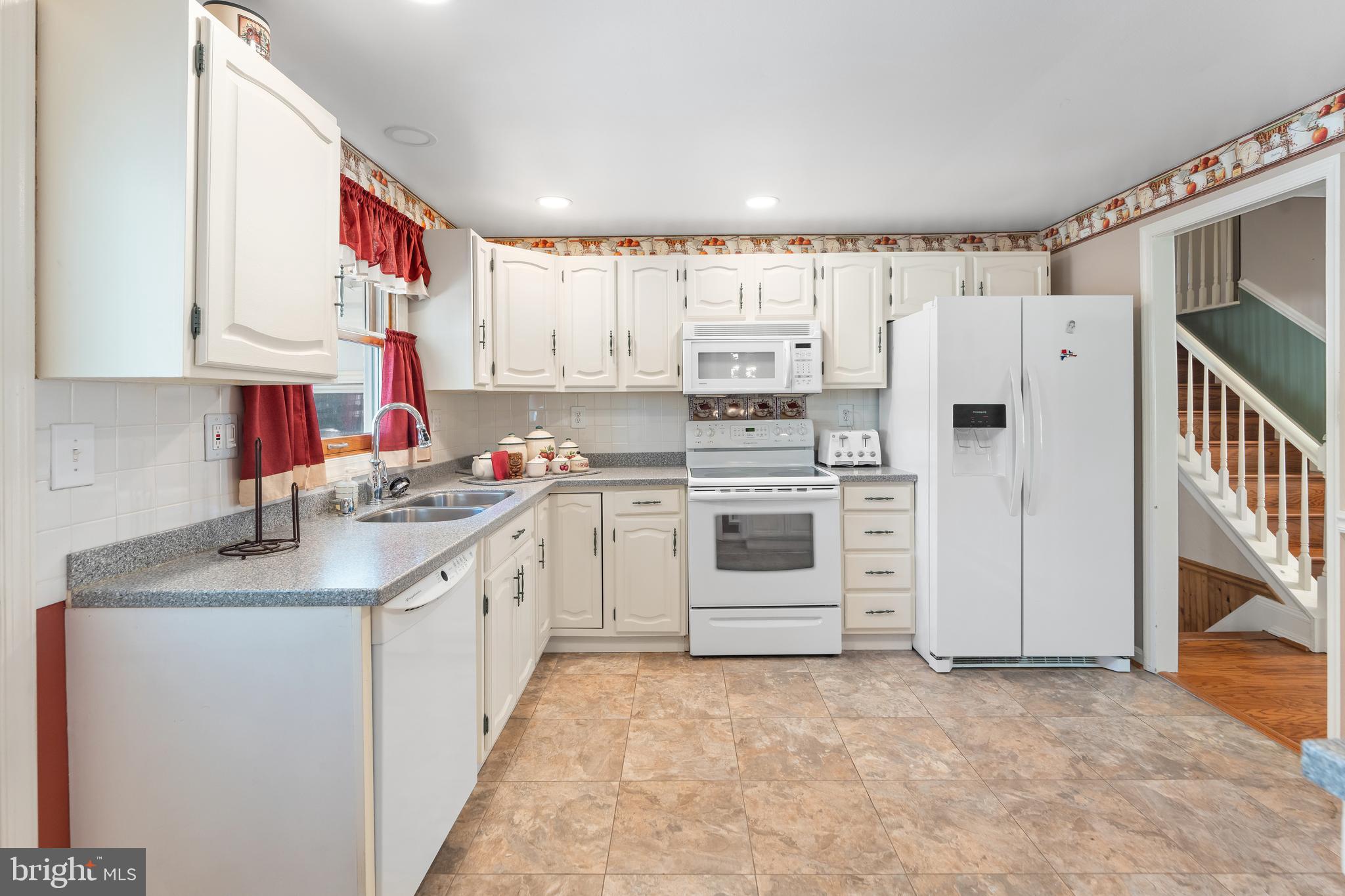 5922 Michael Road Waldorf, MD 20601 - Photo 16 of 43 a kitchen with granite countertop a sink stainless steel appliances and white cabinets