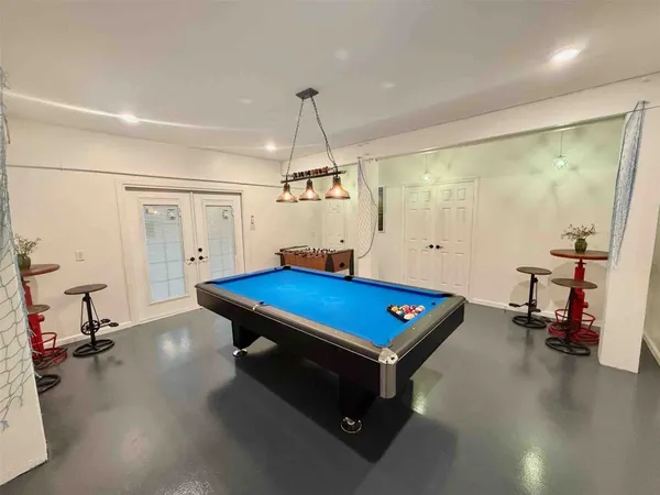 a room with pool table and wooden floor