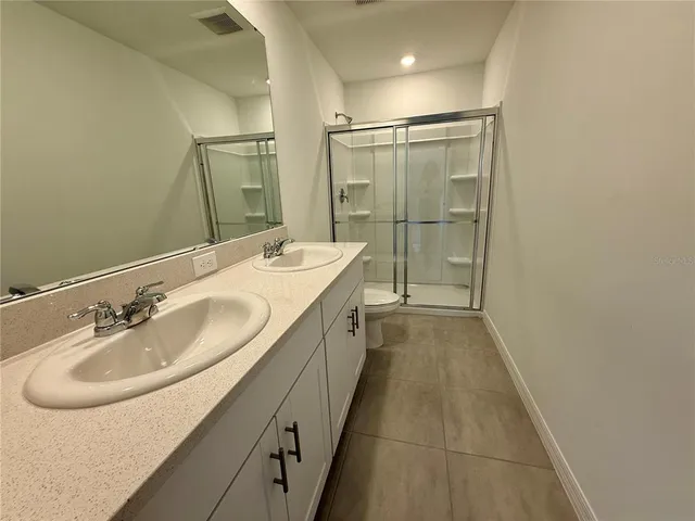 a bathroom with a granite countertop toilet sink and mirror
