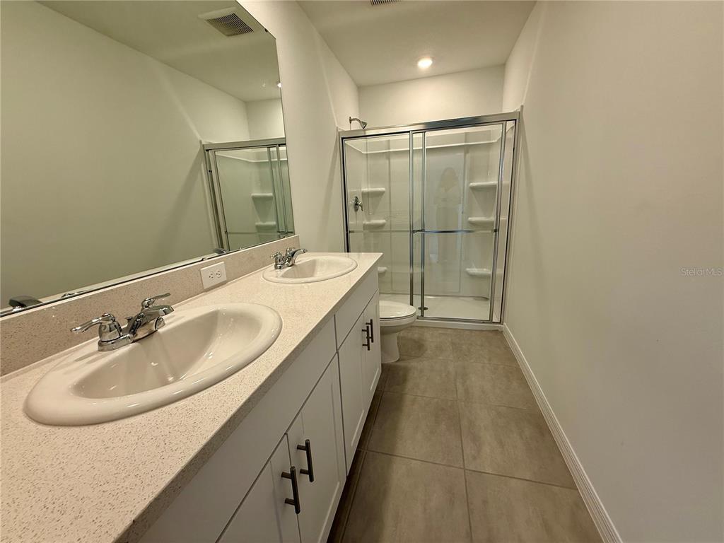 2996 Skyline Loop Kissimmee, FL 34758 - Photo 16 of 26 a spacious bathroom with a double vanity sink mirror and shower