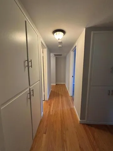 a view of a hallway with wooden floor