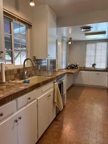a large kitchen with granite countertop a sink and cabinets