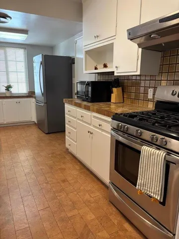 a kitchen with granite countertop a stove and a refrigerator