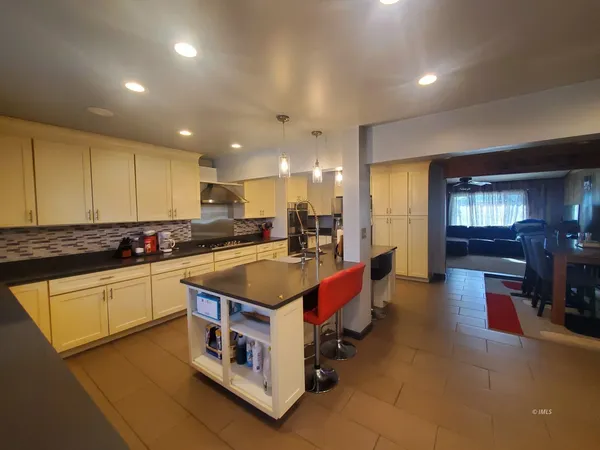 a kitchen with granite countertop a refrigerator a stove and a dining table