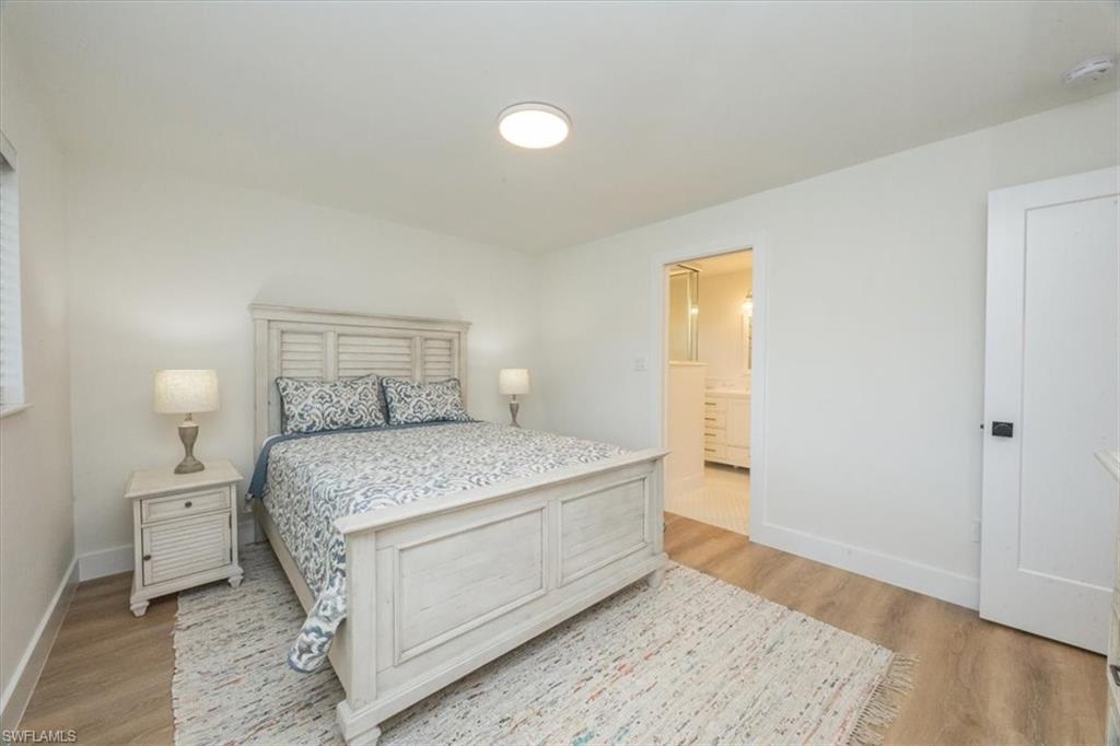 3560 Corana Way Naples, FL 34105 - Photo 13 of 24 a bedroom with a bed and wooden floor