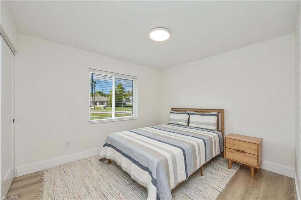 3560 Corana Way Naples, FL 34105 - Photo 17 of 24 a bedroom with a bed and wooden floor