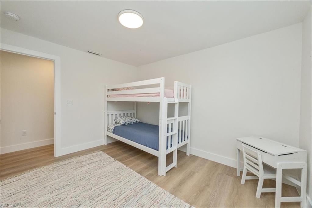 3560 Corana Way Naples, FL 34105 - Photo 19 of 24 a bedroom with a bunk bed and wooden floor