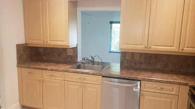 a kitchen with granite countertop white cabinets and sink