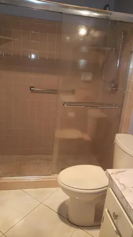 a white toilet sitting next to a bath tub and shower