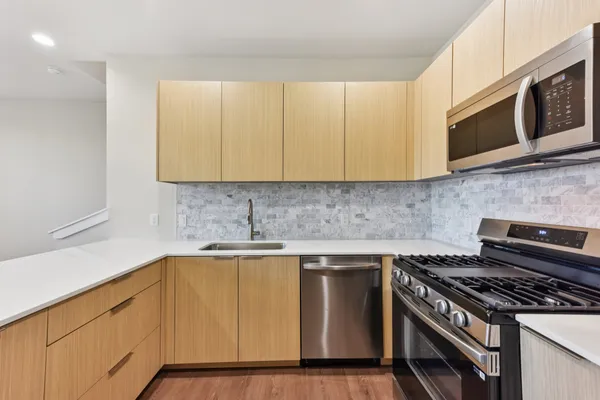 a kitchen with stainless steel appliances a stove a microwave sink and cabinets