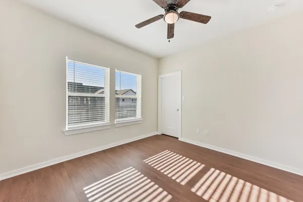 an empty room with a window and a ceiling fan