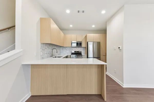 a view of kitchen with stainless steel appliances granite countertop cabinets and wooden floor