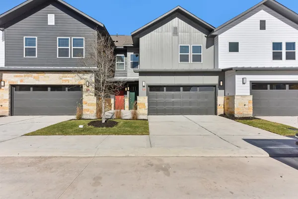 a front view of a house with a yard and a garage