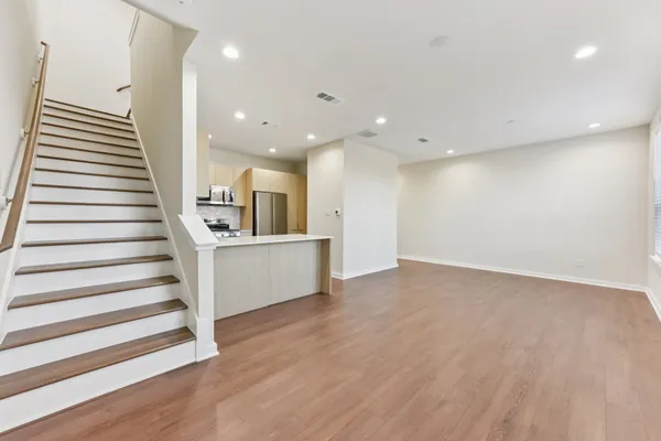 a view of a kitchen with stairs and wooden floor
