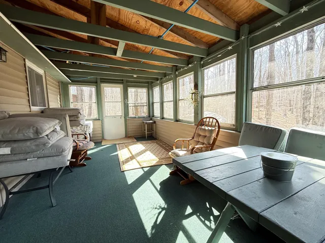 a view of a chairs and table in patio with wooden floor