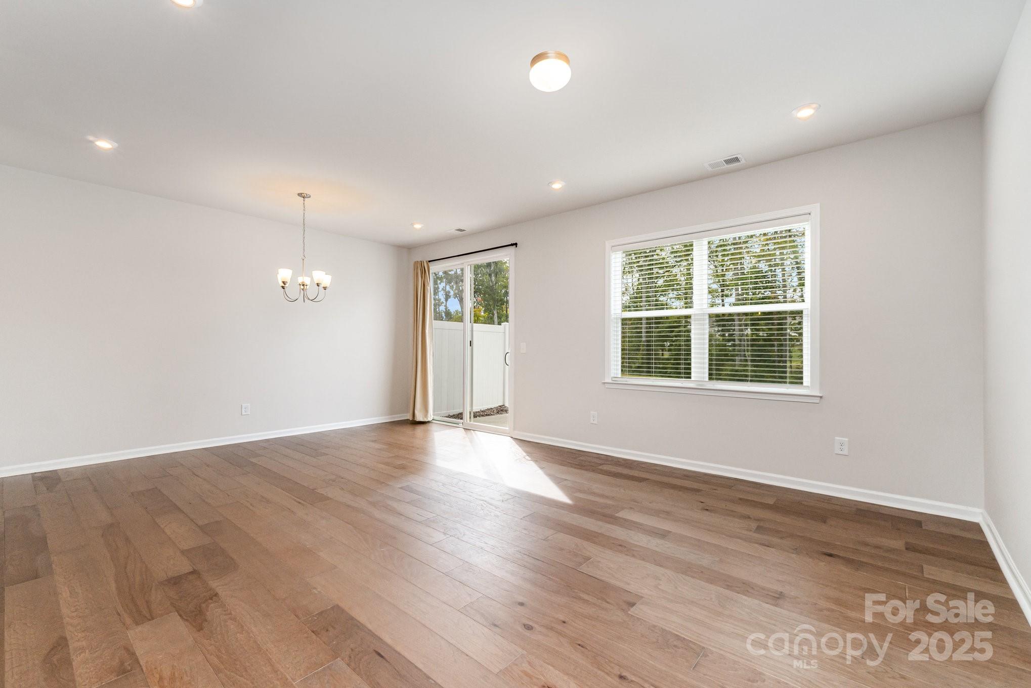9029 Widden Way Charlotte, NC 28269 - Photo 14 of 29 an empty room with wooden floor and windows