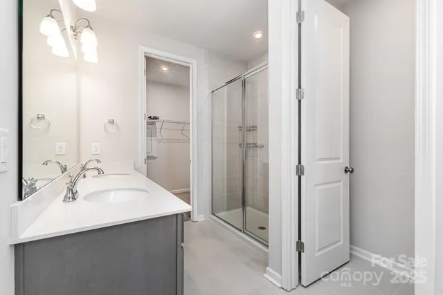 a bathroom with a double vanity sink mirror and shower