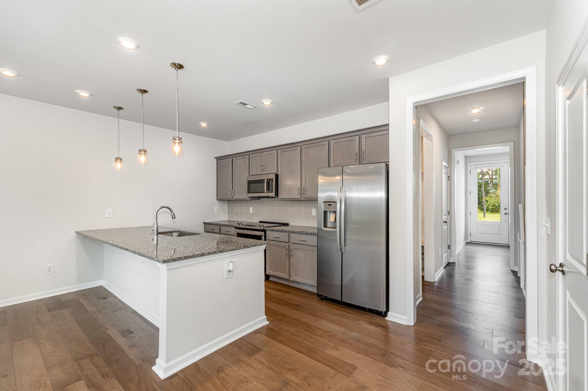 9029 Widden Way Charlotte, NC 28269 - Photo 5 of 29 a kitchen with stainless steel appliances granite countertop a sink and a refrigerator