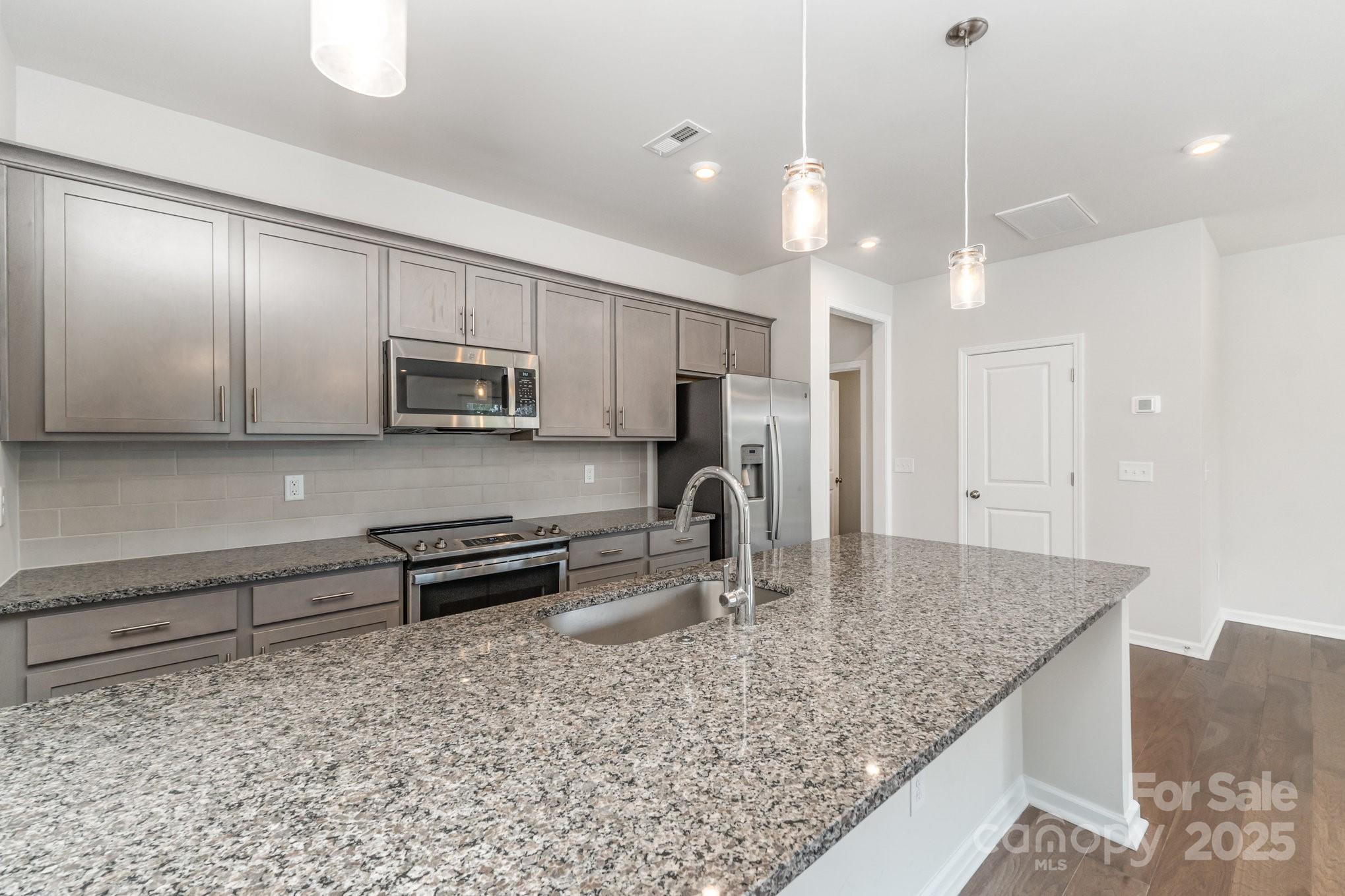 9029 Widden Way Charlotte, NC 28269 - Photo 6 of 29 a kitchen with stainless steel appliances granite countertop a sink refrigerator and microwave