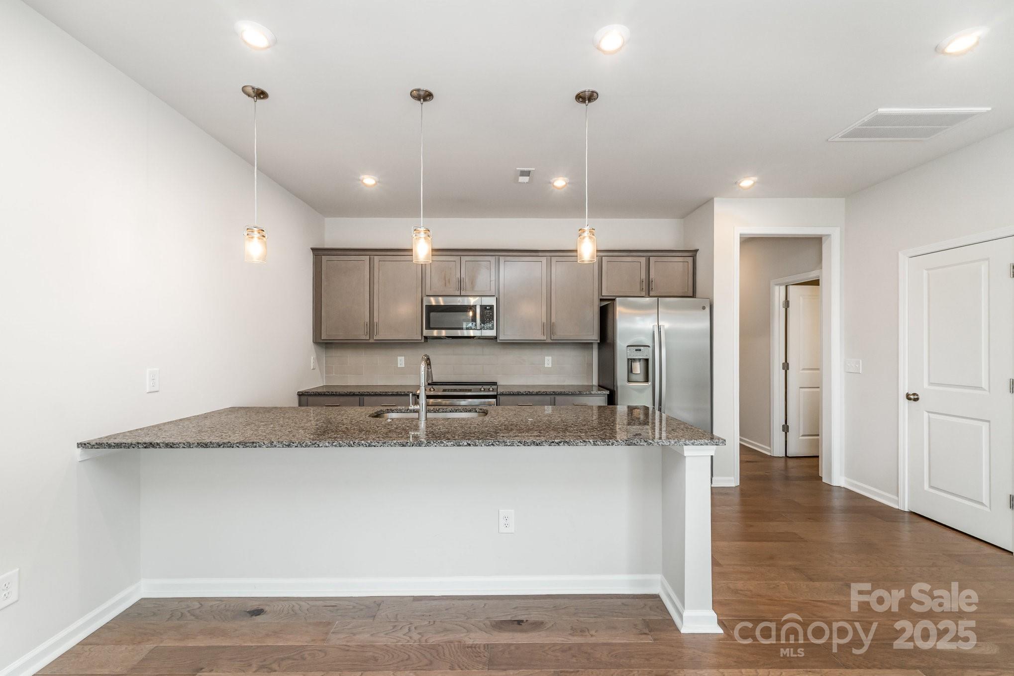 9029 Widden Way Charlotte, NC 28269 - Photo 8 of 29 a large kitchen with stainless steel appliances granite countertop a large counter top a sink and a refrigerator