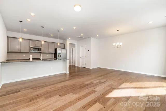 a view of kitchen with kitchen island white cabinets and wooden floor
