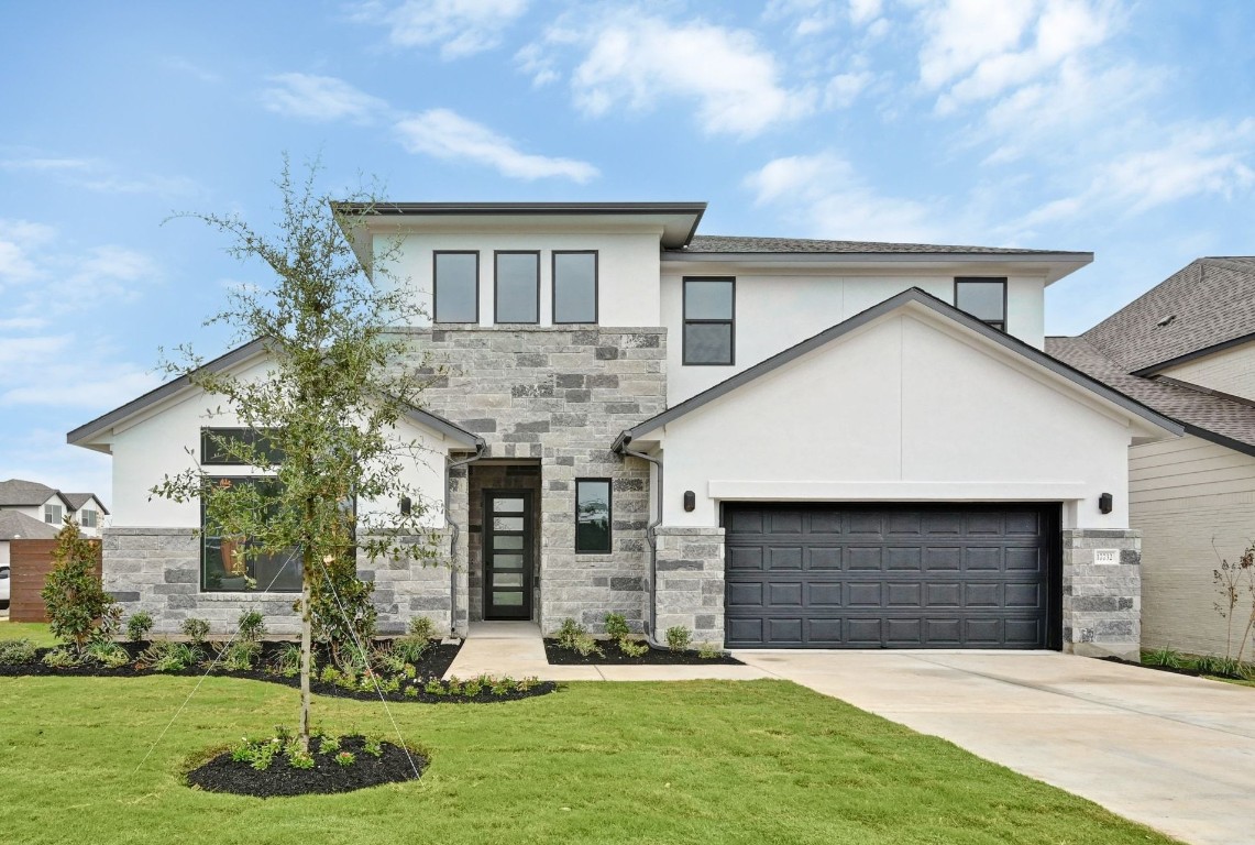 a front view of a house with a yard and garage
