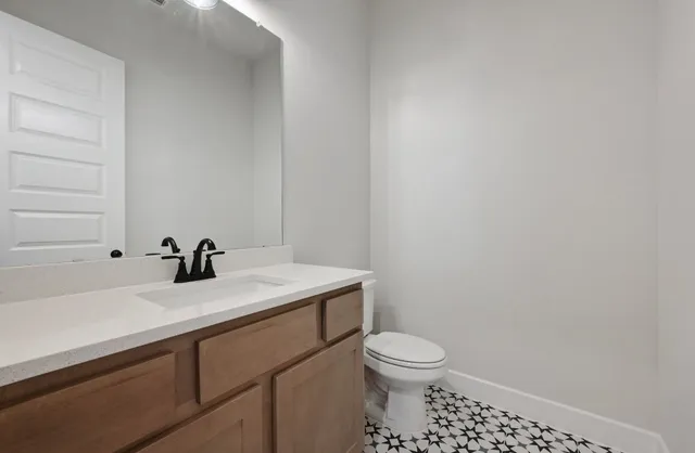 a bathroom with a sink a toilet and mirror