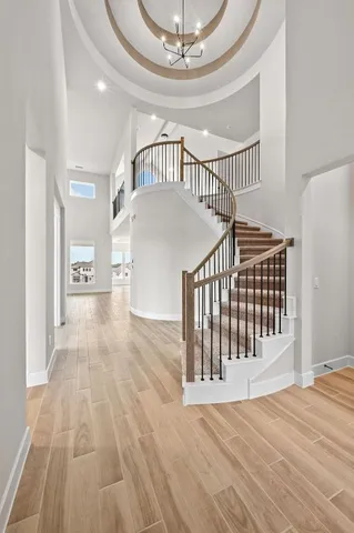 a view of a hallway with wooden floor and staircase