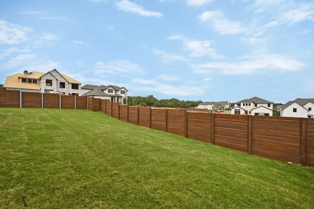 a view of a green field with wooden fence