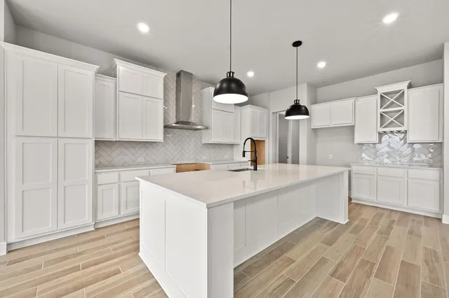 a kitchen with kitchen island a sink stainless steel appliances and cabinets