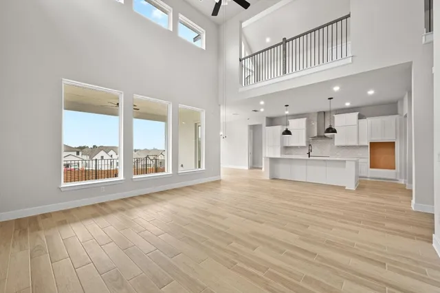 a view of an empty room with a window and kitchen view