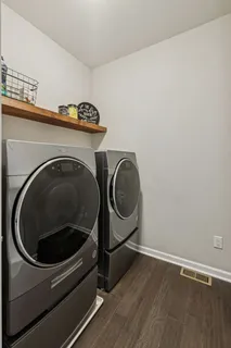 a living room with stainless steel appliances furniture a fireplace a flat screen tv and kitchen view