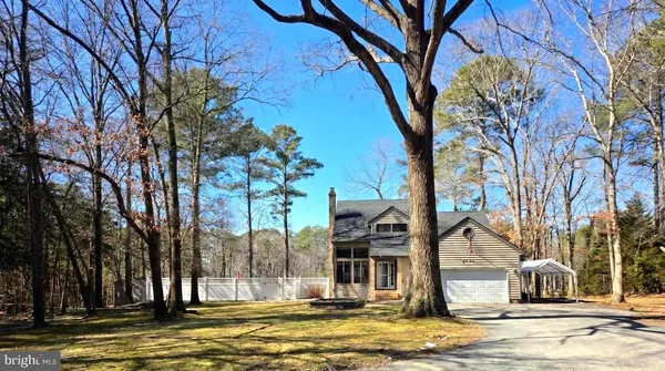 a view of a house with a yard covered with snow and tree