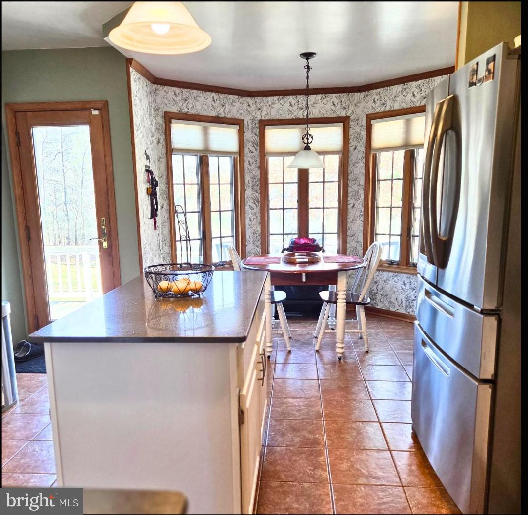5632 Galestown - Reliance Road Rhodesdale, MD 21659 - Photo 13 of 29 a kitchen with stainless steel appliances granite countertop a refrigerator a sink dishwasher a stove and a dining table with wooden floor