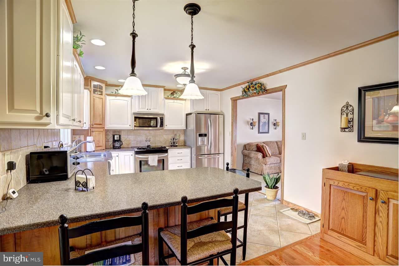5 Rettinger Road Halifax, PA 17032 - Photo 8 of 25 a kitchen with stainless steel appliances granite countertop a stove a sink a refrigerator a center island a dining table and chairs with wooden floor